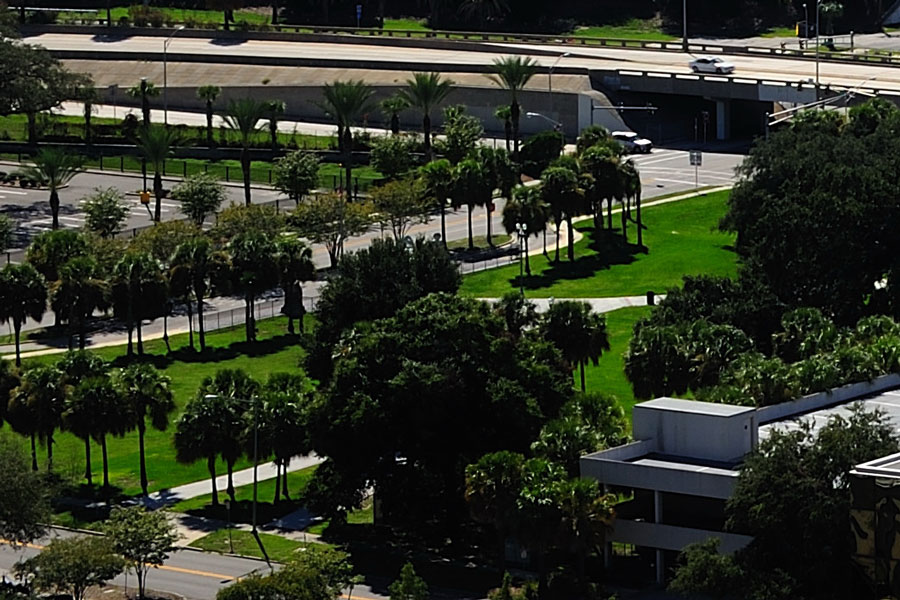 an aerial view of a highway, cityscape and palm trees