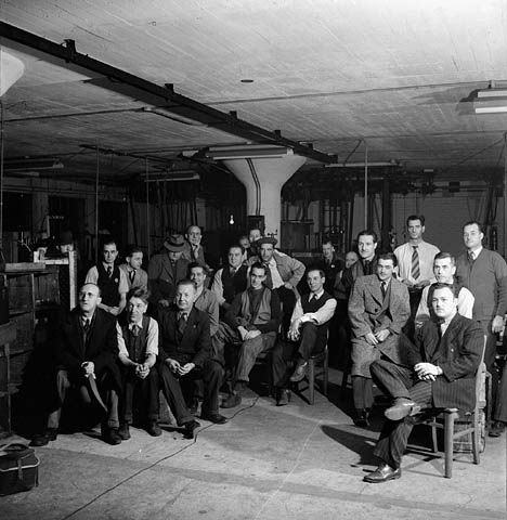 group of people sitting on chairs in a warehouse