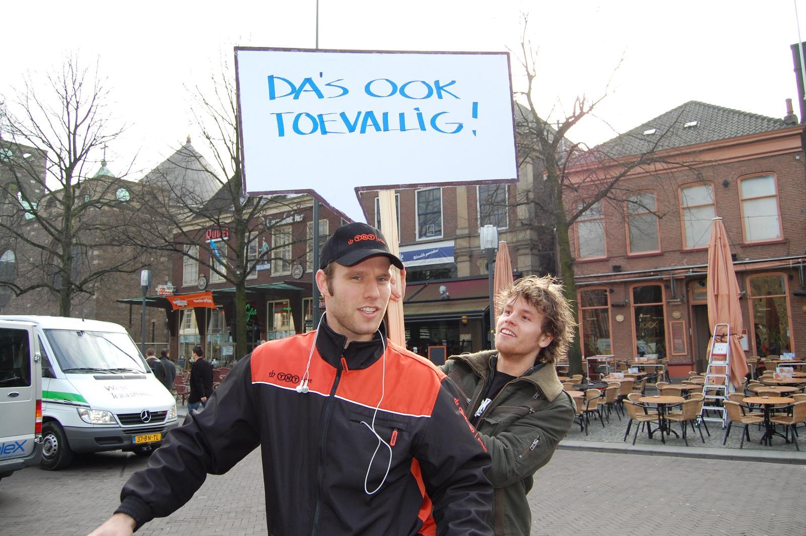 two men with hats holding onto a sign