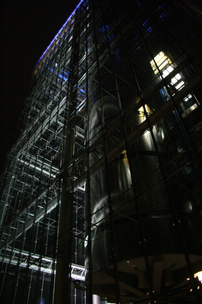 a large glass building with windows next to a clock
