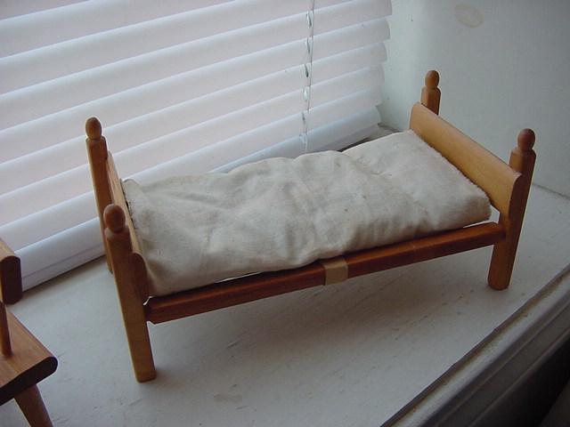 a bed with one pillow attached to the side of it
