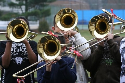 young men playing trombones in a school band