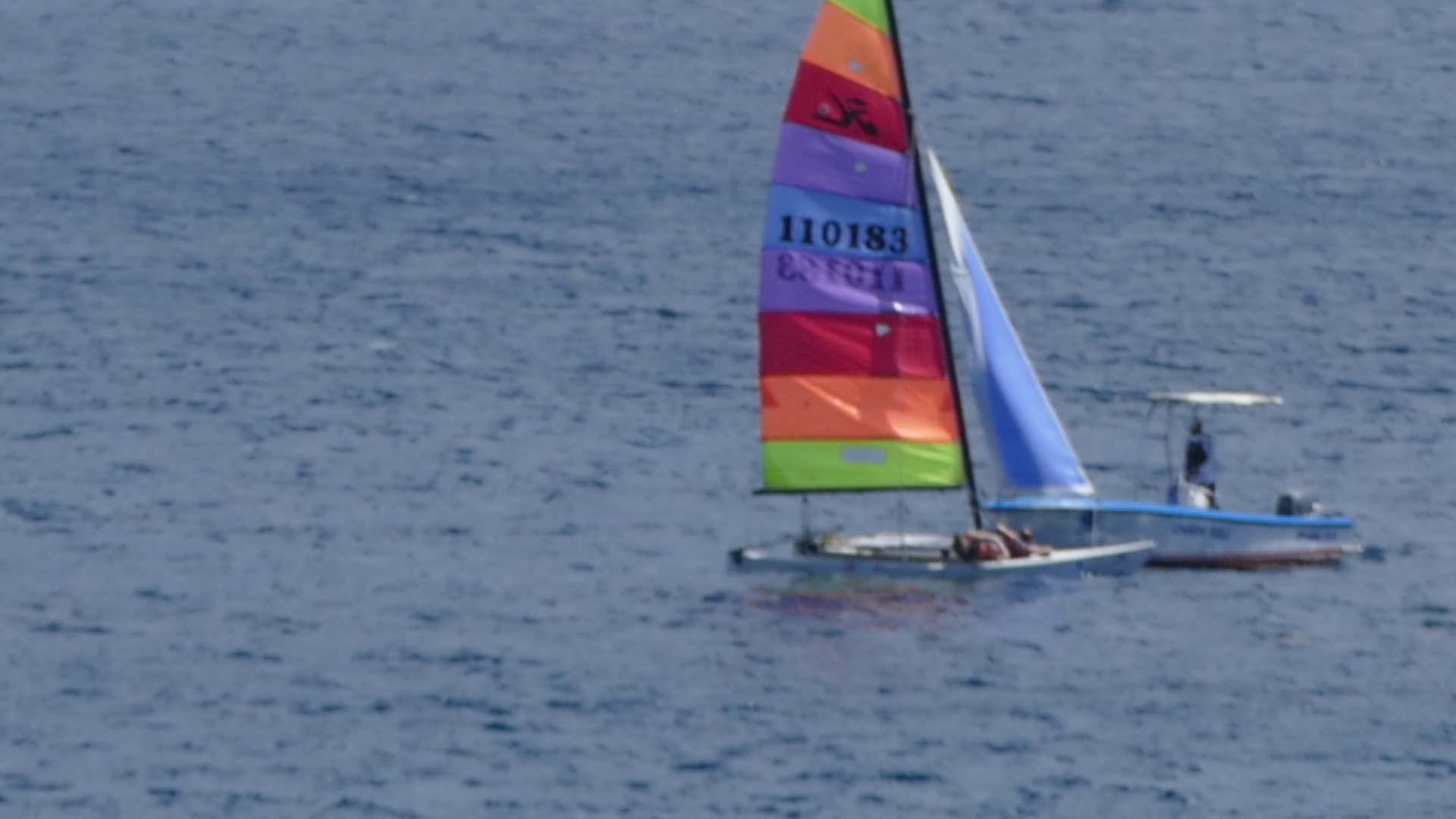 a small sailboat in the middle of some water