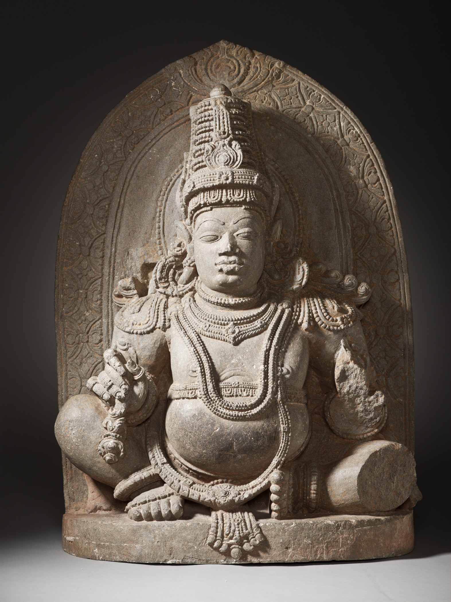 sculpture of sitting buddha on pedestal in center of room