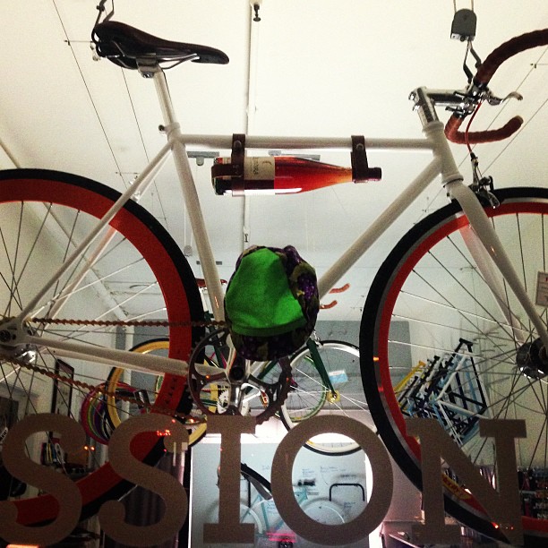 a white bike in a display with bicycles hanging from the ceiling