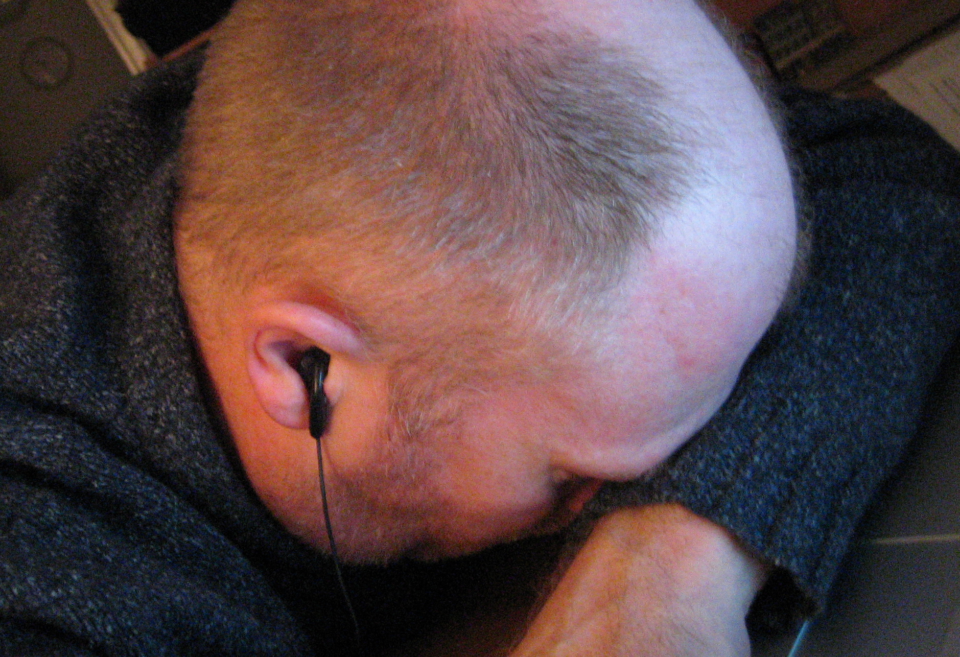 a man is leaning on his head with a pair of earphones