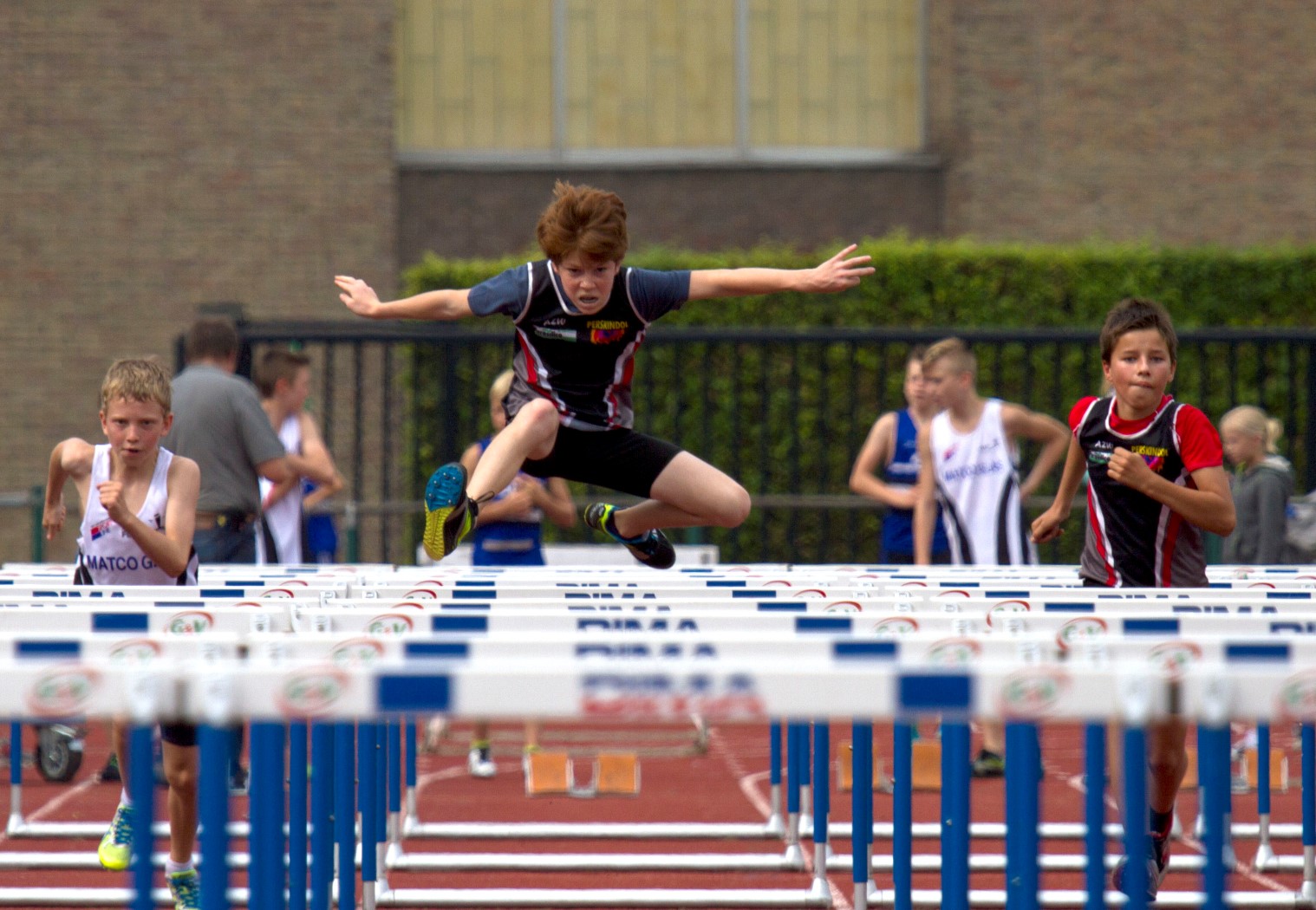 a man leaps above the hurdles to win a race