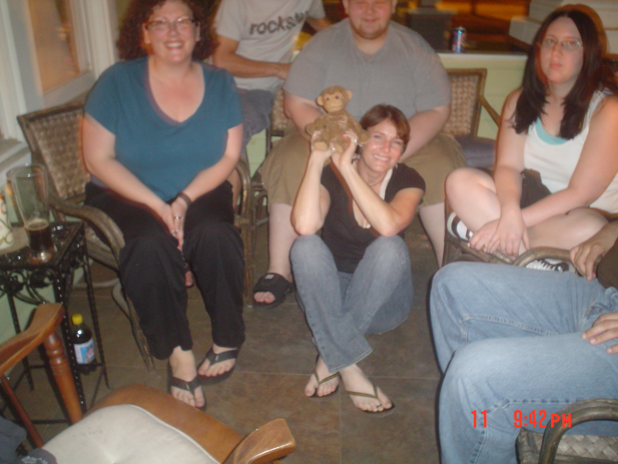 several people sitting in chairs while one holds a stuffed bear