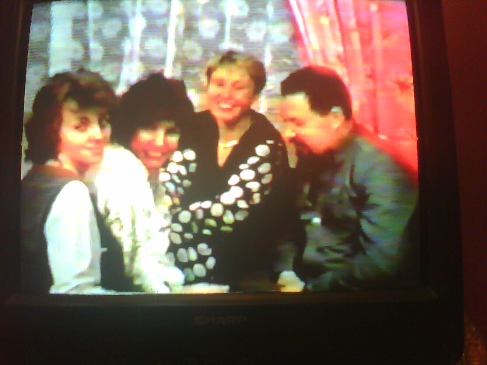 an old po of four women smiling while standing together