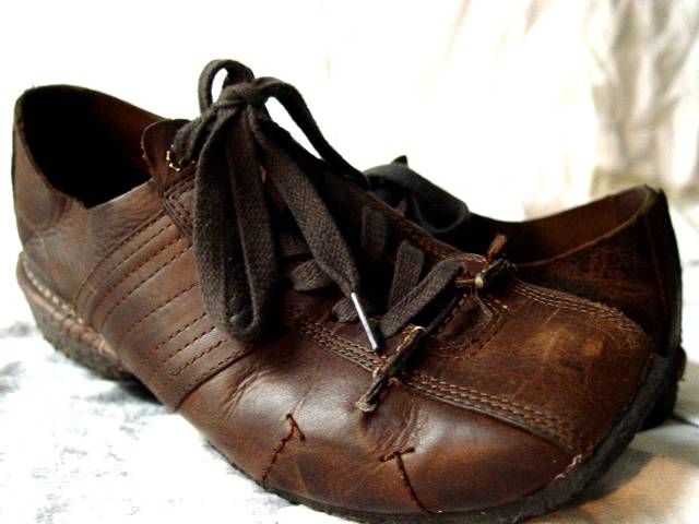 a pair of brown shoes with one worn on
