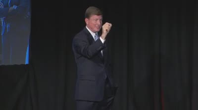 a man in a suit standing on a stage