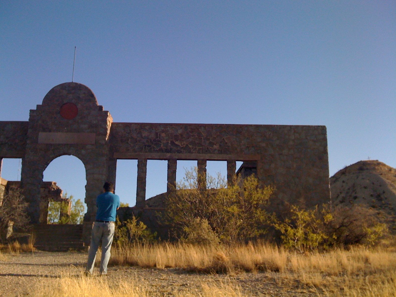 a man looking up at the structure with an arch