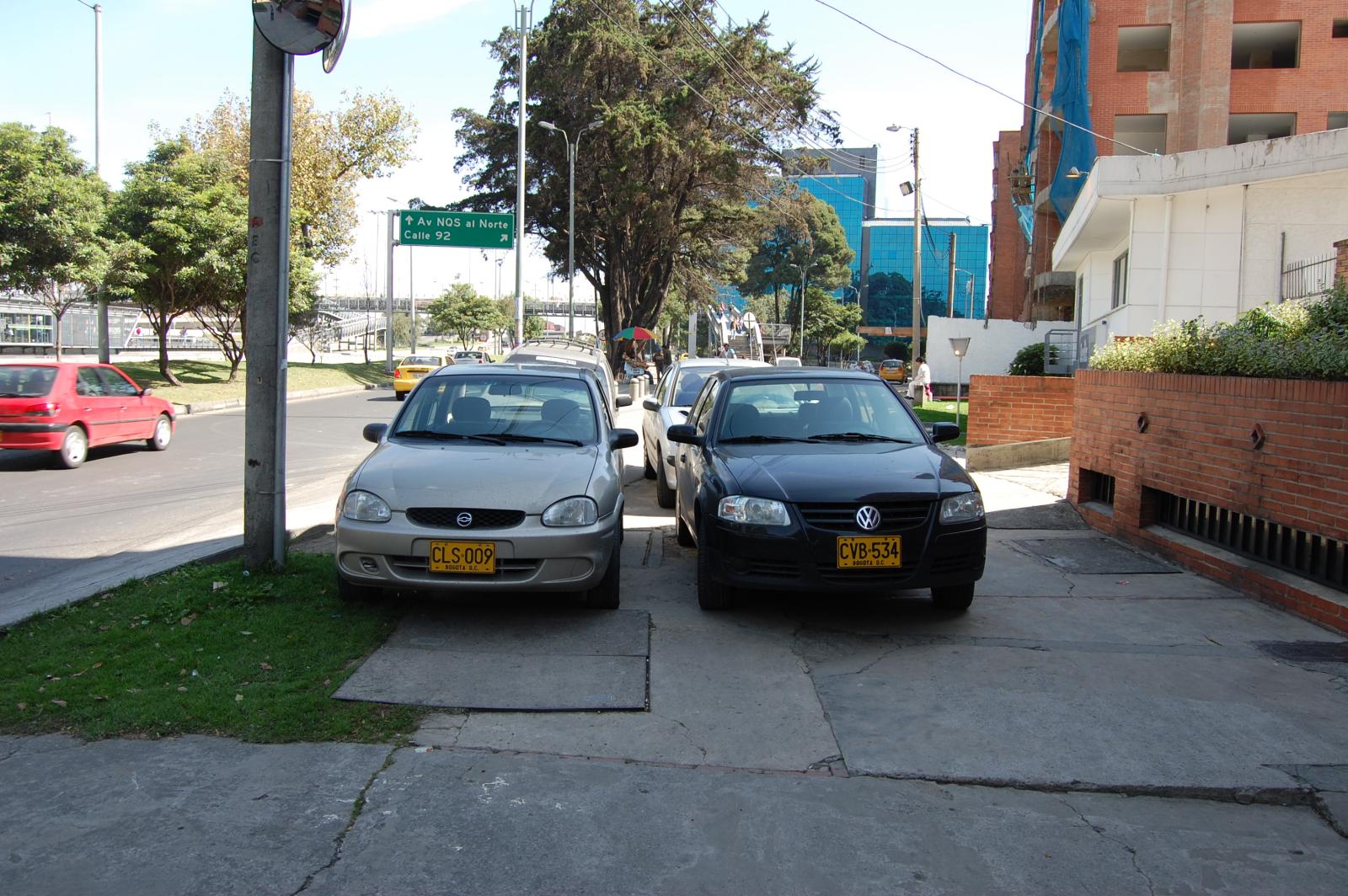 two cars are parked along the side of a street