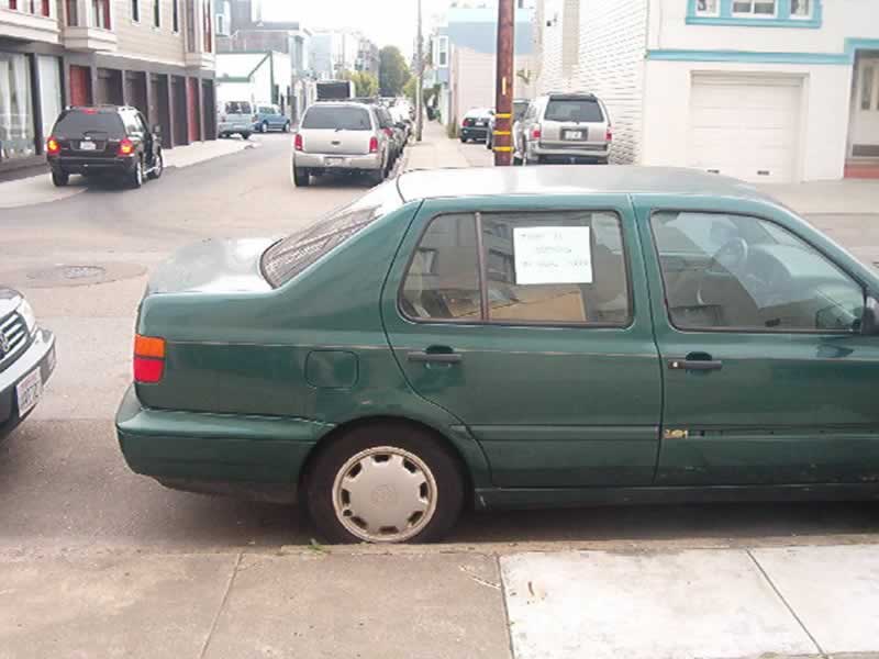 a car parked on the street next to a pole