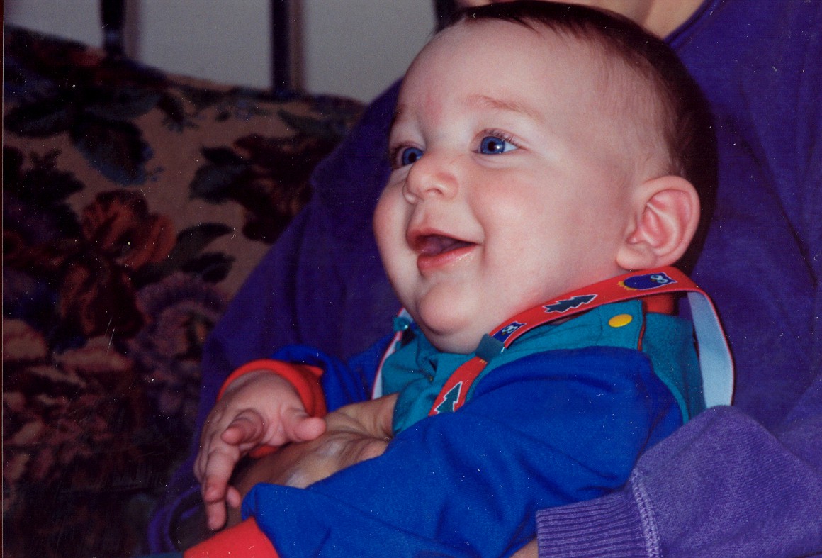 the baby is happy as she sits on the couch