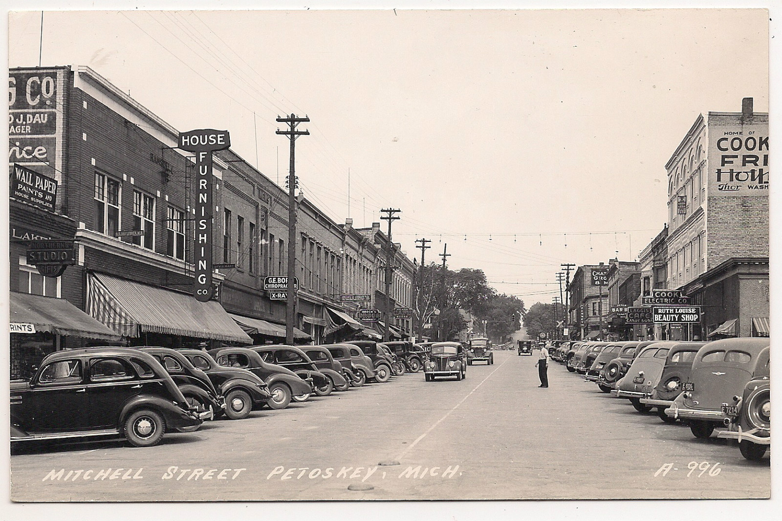 an old pograph of cars parked at curbside