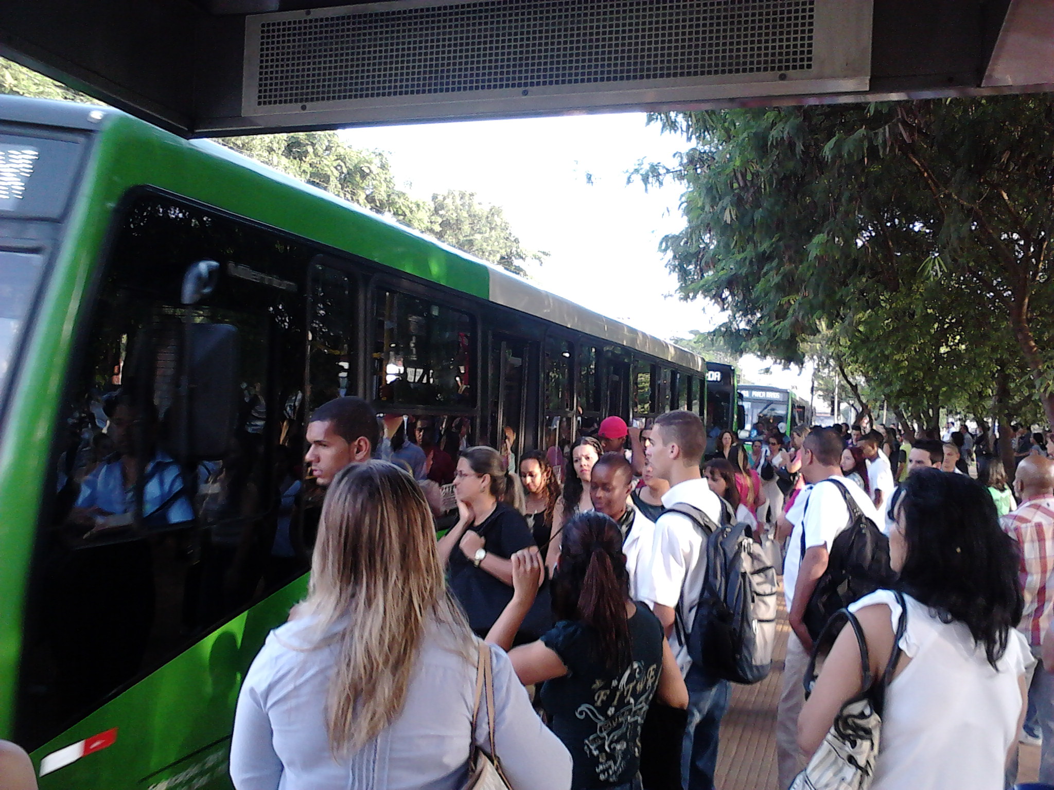 a crowd of people that are standing in front of a bus