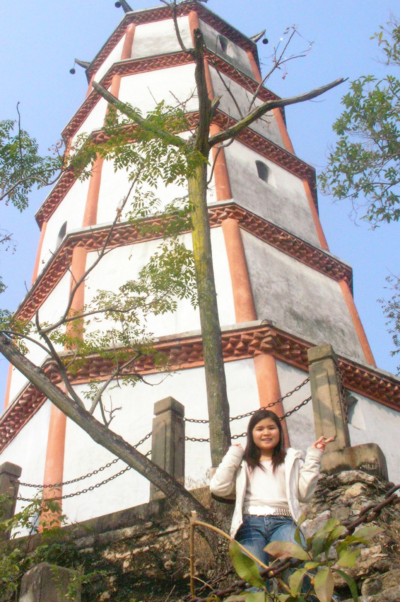 young woman standing next to a tall tower