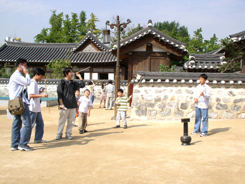 several people are in a courtyard with asian architecture