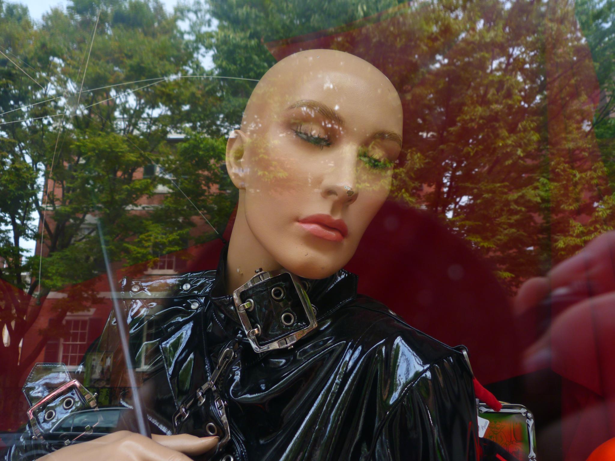 a mannequin heads dressed in black with a metal ring on the neck