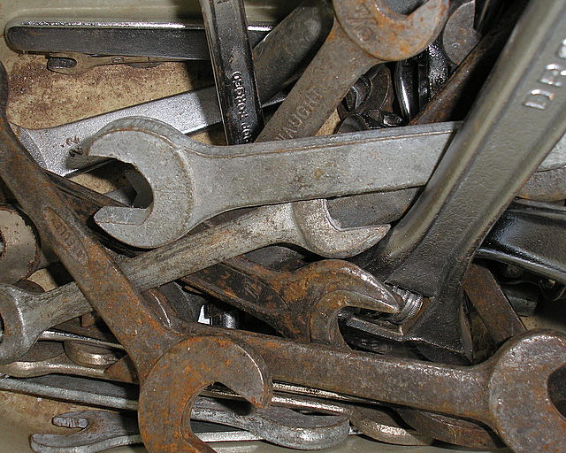several rusty wrenches and screwdrives piled in rows