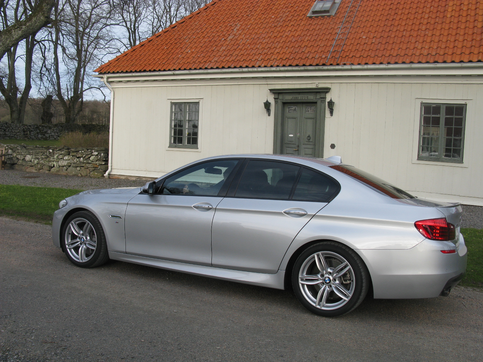 a silver car parked next to a white building