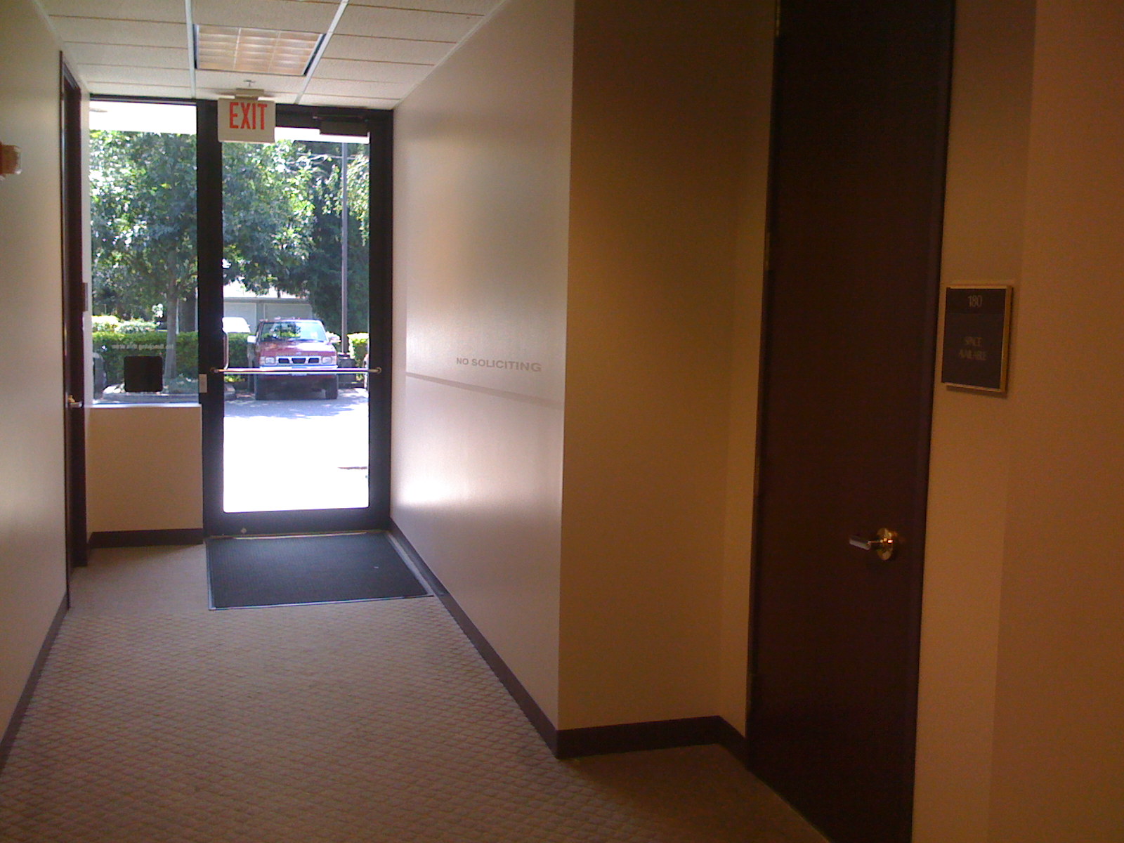 an empty hallway with no doors and a brown door