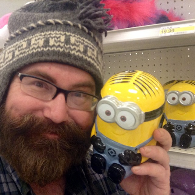 a man with beard wearing glasses and a yellow minion in his hand