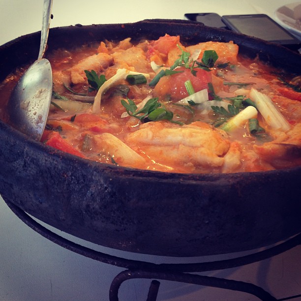 a bowl of fish stew with a spoon