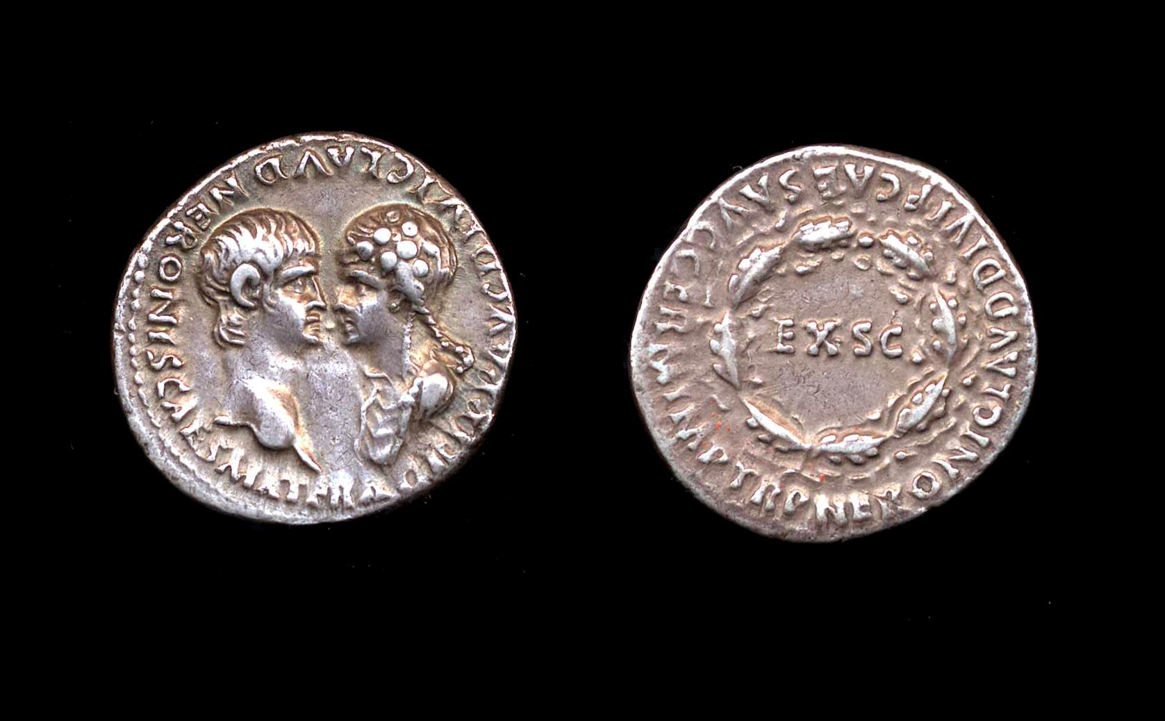 two roman coins side by side in the dark