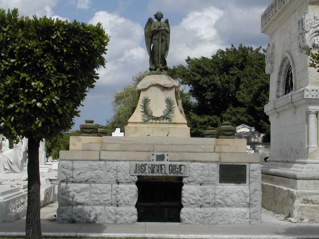 a statue is standing near some trees on a street