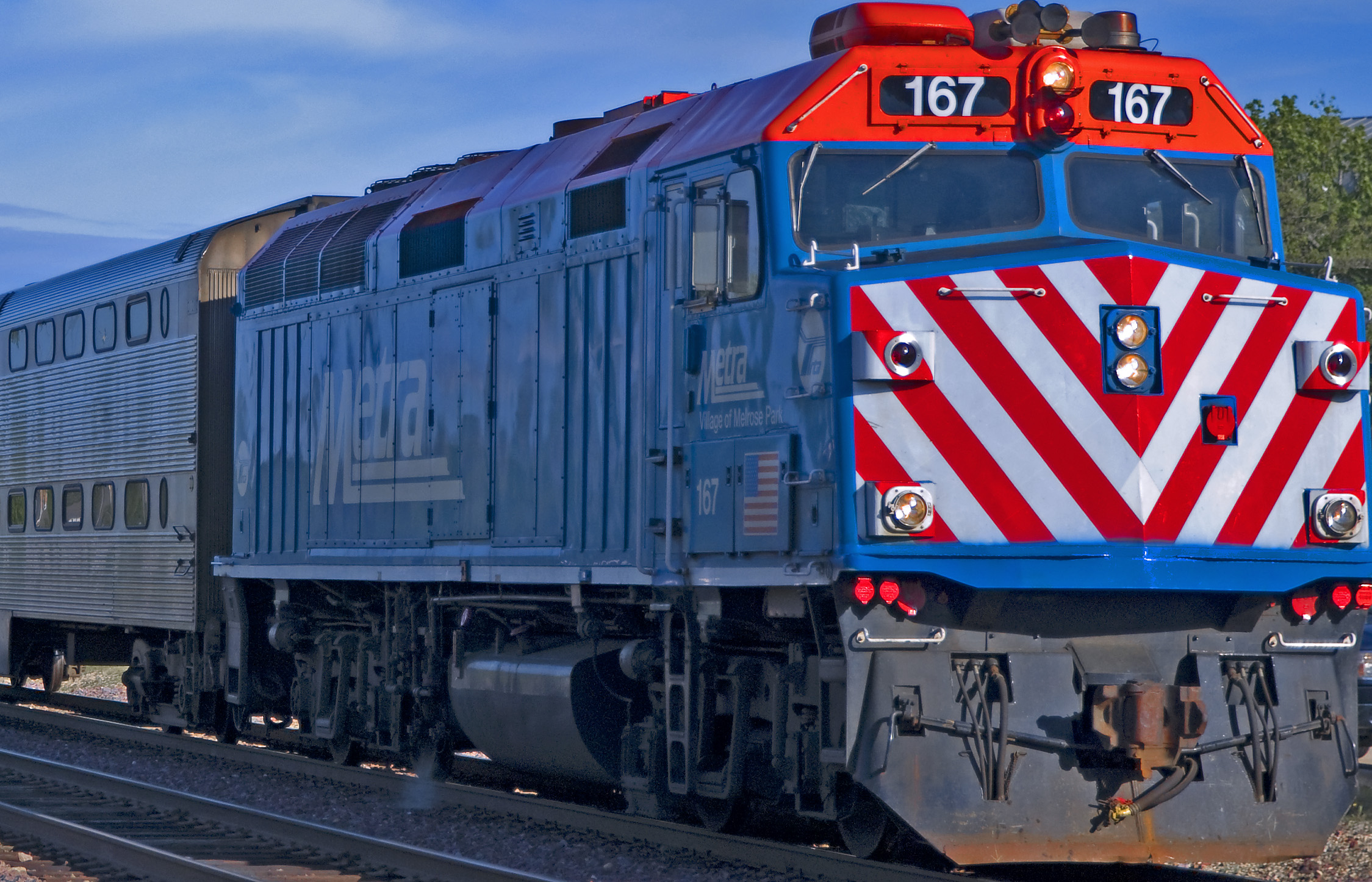 a train on a track is painted red, white and blue