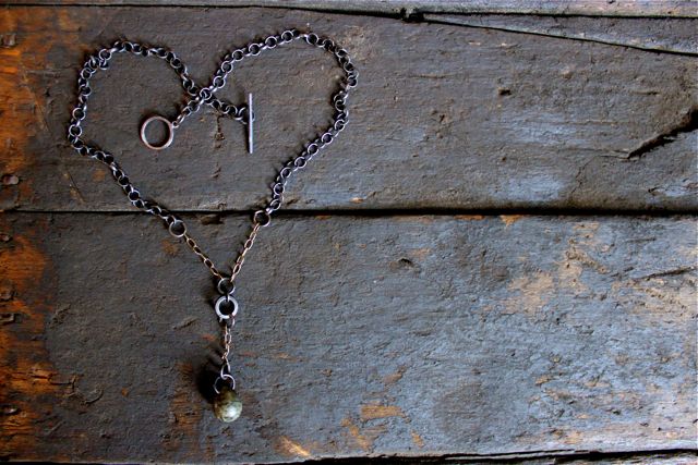 an antique bead and necklace attached to a chain