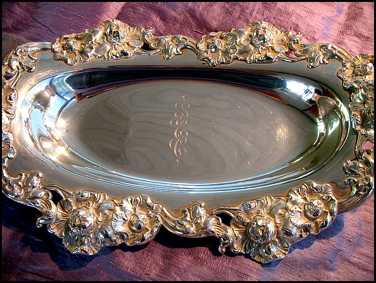 an oval tray with a floral design on the edge of it