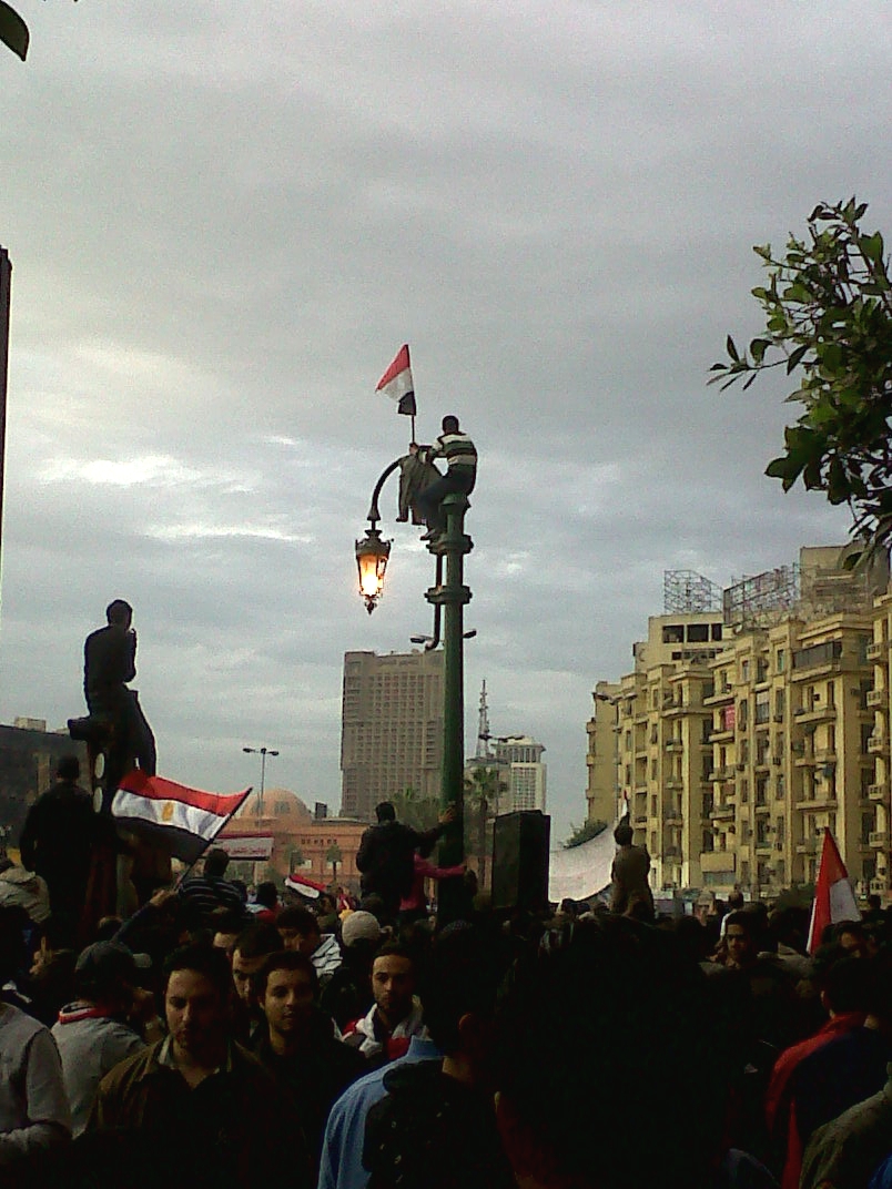 a street lamp sitting next to a crowd of people