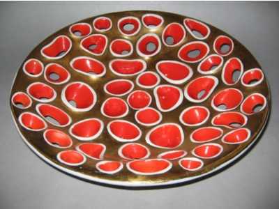 a decorative tray in red and white, with small circles on the center