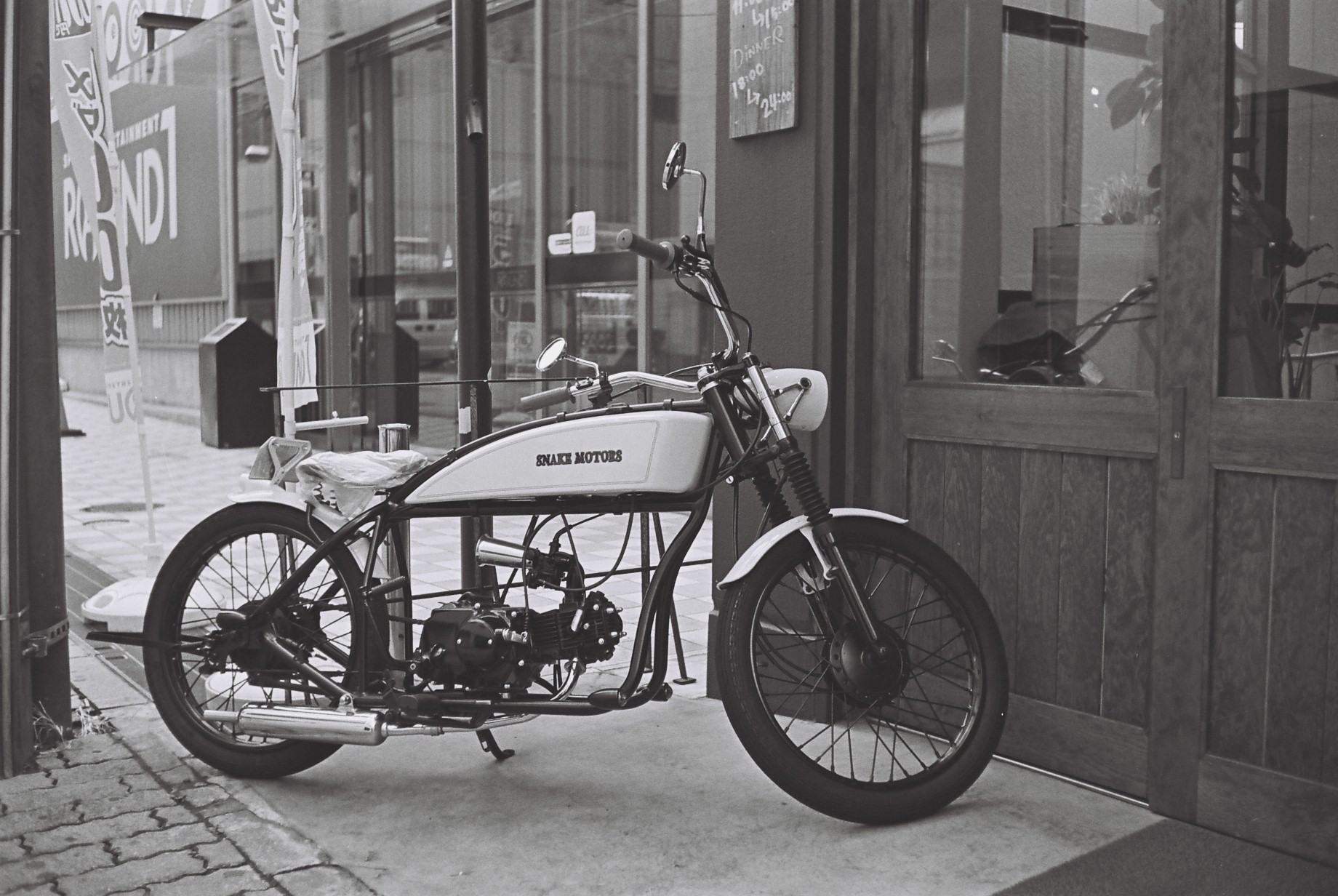 a black and white po shows a motorcycle parked outside a building