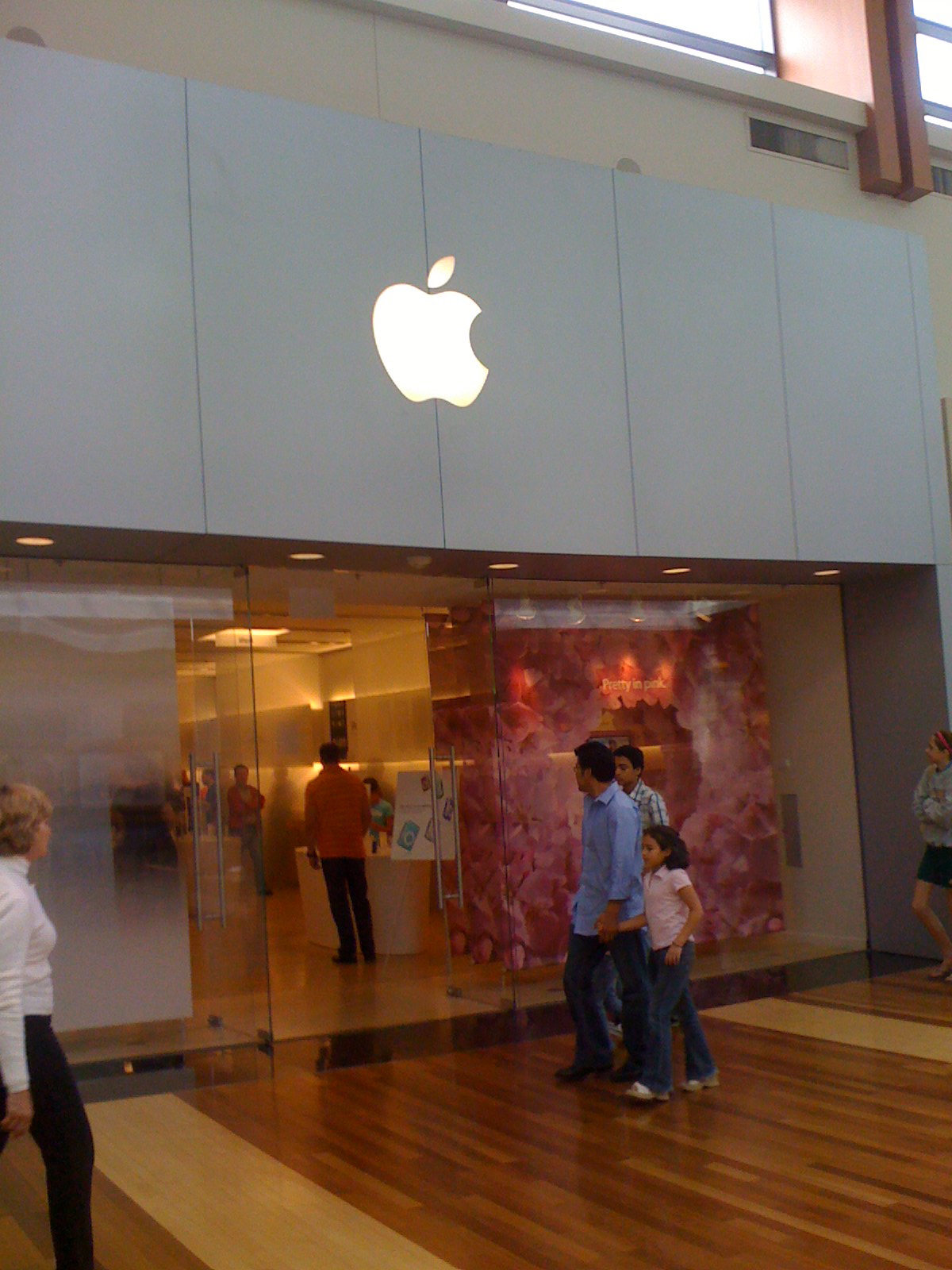 people stand inside a building and look at the apples logo