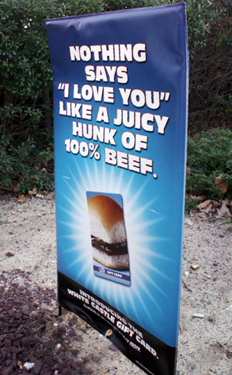 a large sign advertising food on the side of the road
