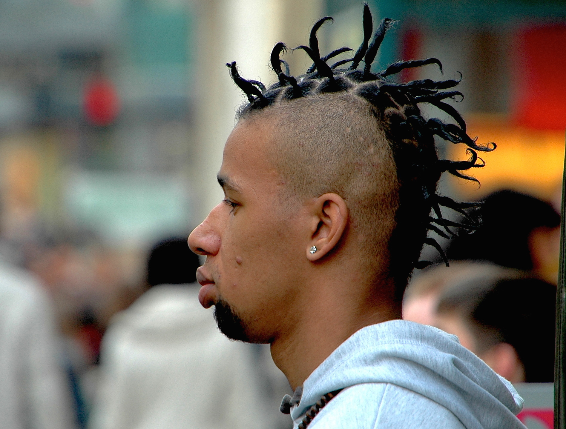 a young man with dreadlocks stares to the side