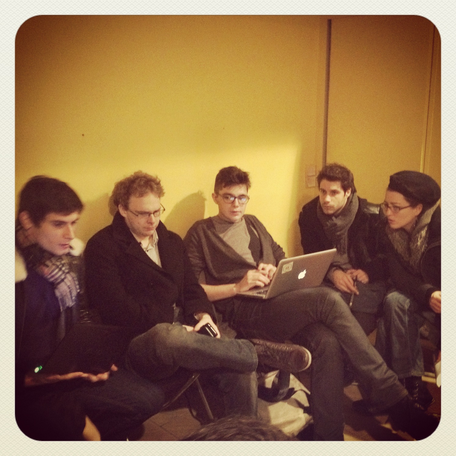 several men sitting together with a laptop