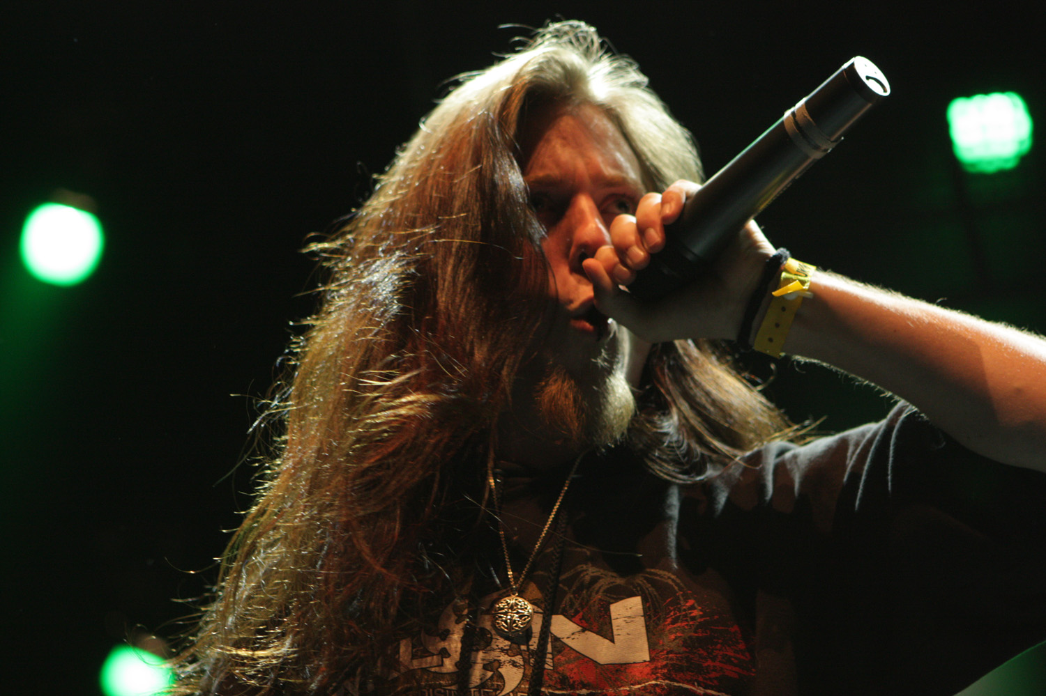 the singer has long hair, and he is holding a microphone