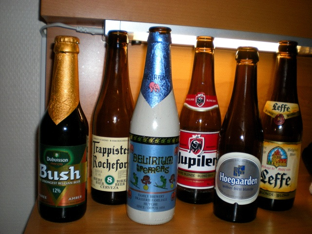 a bunch of beer bottles that are sitting on a shelf