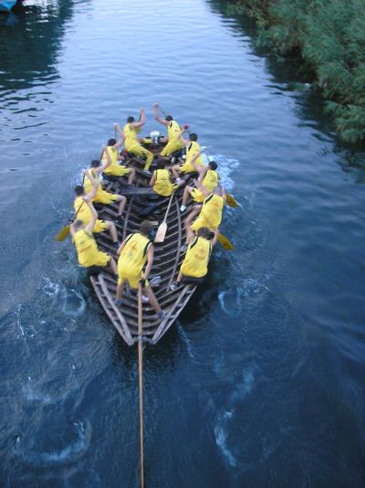 the group is rowing on the water using a large boat