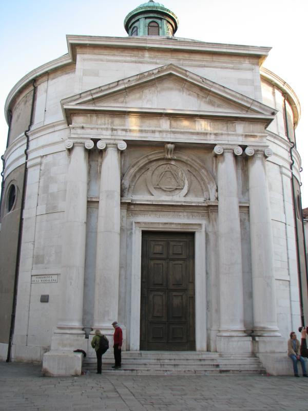 there is a two doored church with arches and columns