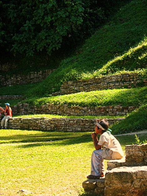 people walking, sitting and standing on a grassy hill top