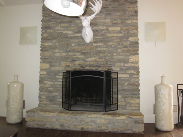 a stone fireplace with an antler head over it