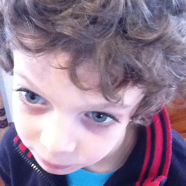 a little boy with blue eyes and curly hair