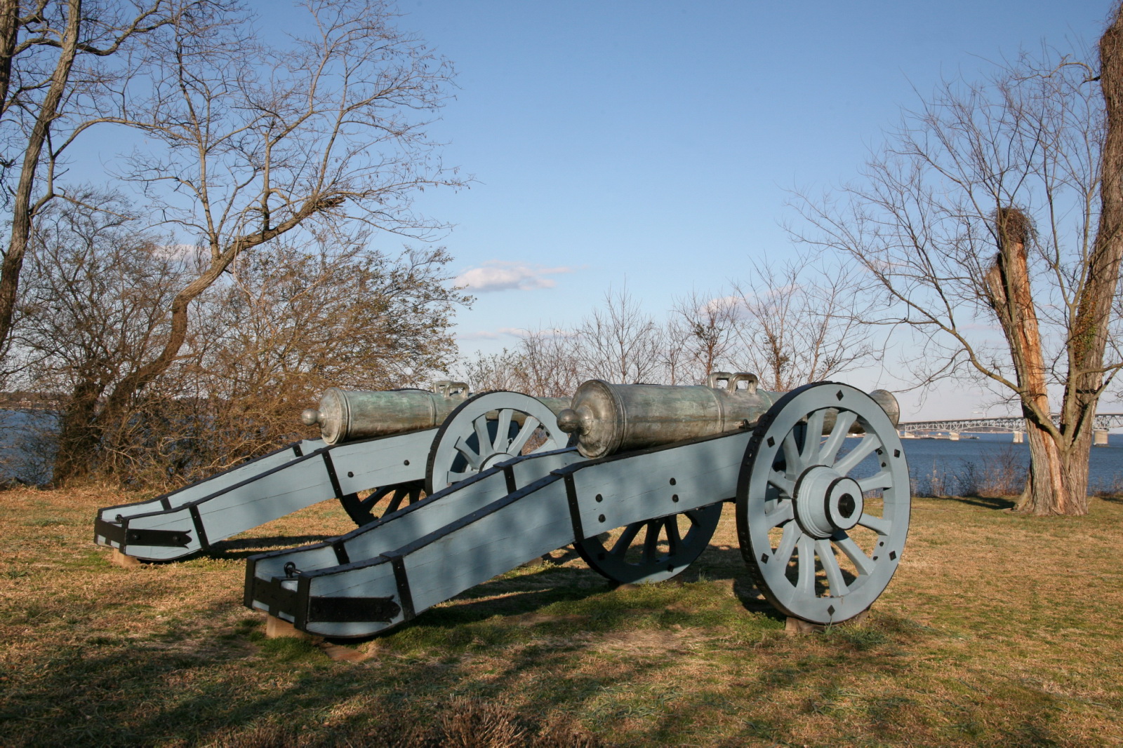 a cannon and gun laying on the ground in the park