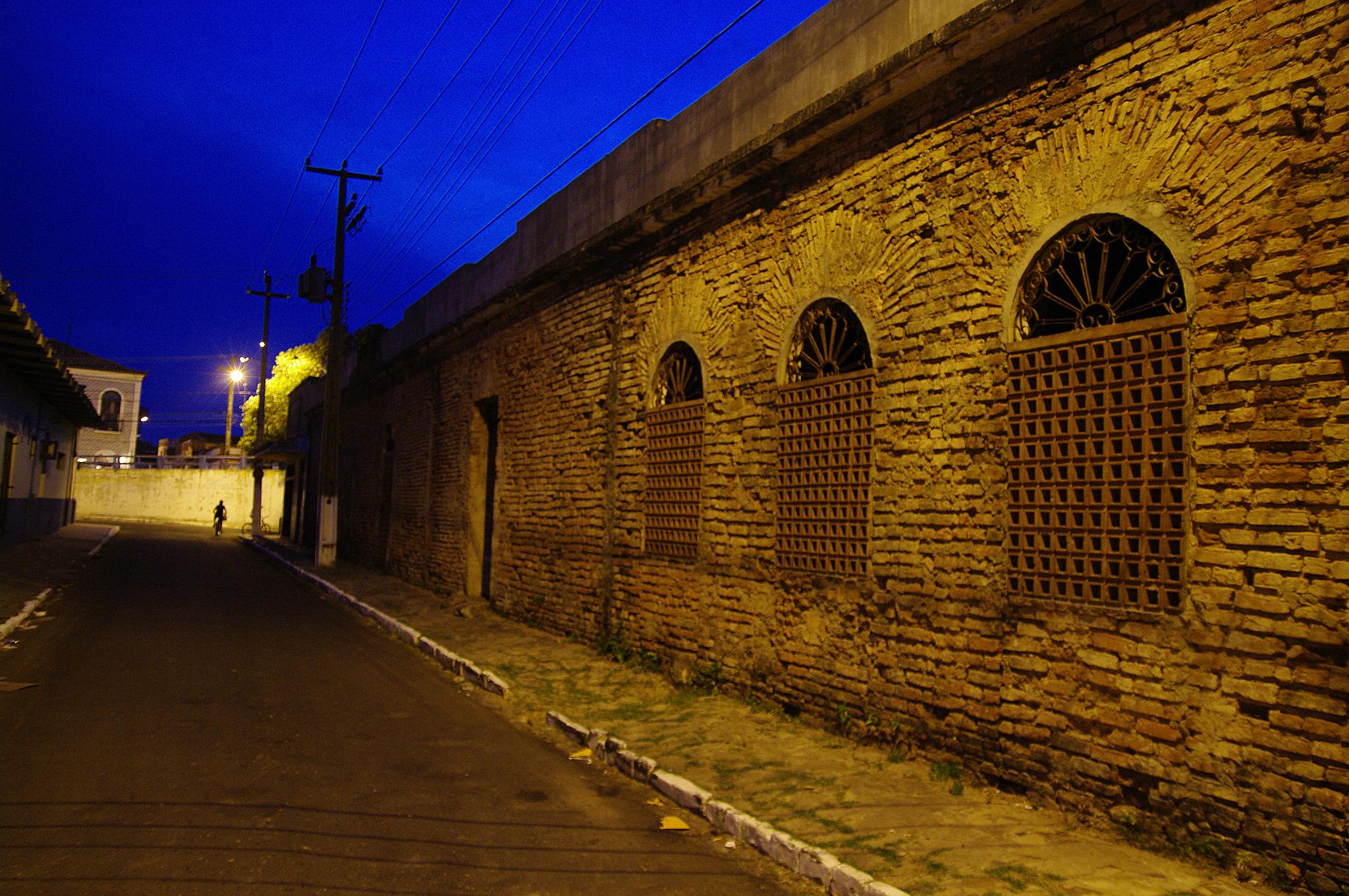 a brick wall and stone street during twilight